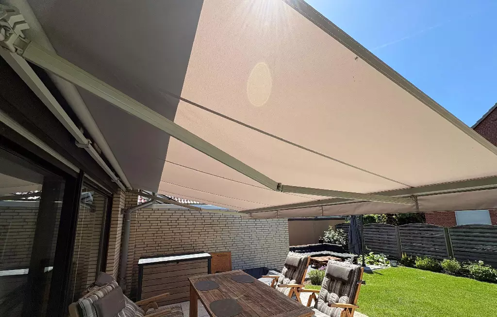Beiges Markisentuch auf offener Markise auf der Terrasse
