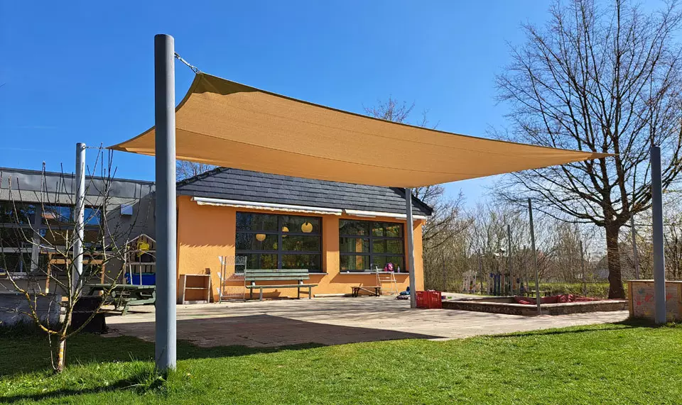 Sonnensegel mit wasserdurchlässigem Stoff in einem Kindergarten