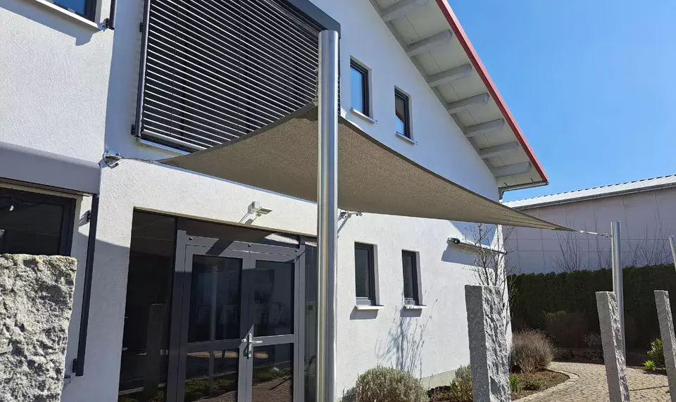 Sonnensegel mit lichtdurchlässigem Stoff an einem Bürogebäude